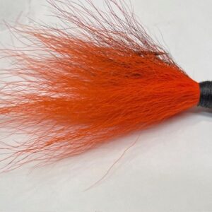 orange bucktail fishing lure with hair on the end